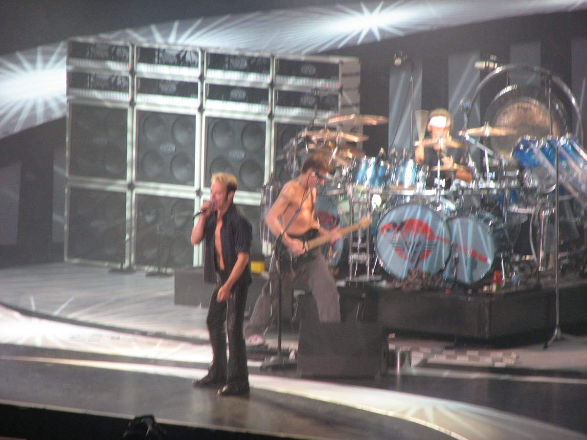 David Lee Roth singing with Eddie Van Halen on guitar and Alex Van Halen at the drums